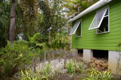 Lime green building and palms at Orchid World in Barbados.jpg