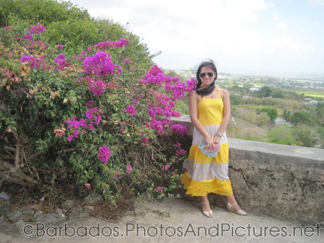 Joann next to pink flowers and wall at Gun Hill Signal Station in Barbados.jpg
